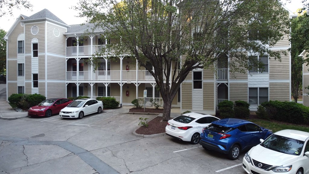 an apartment building with cars parked in front of it