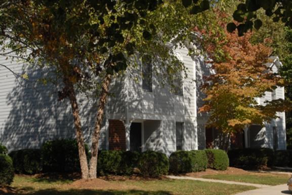 a white house with a tree in front of it