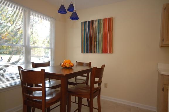 a dining room table with a bowl of fruit on it