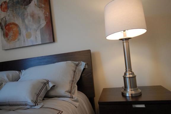 a bedroom with a bed and a lamp on a table