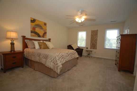 a bedroom with a bed and a ceiling fan