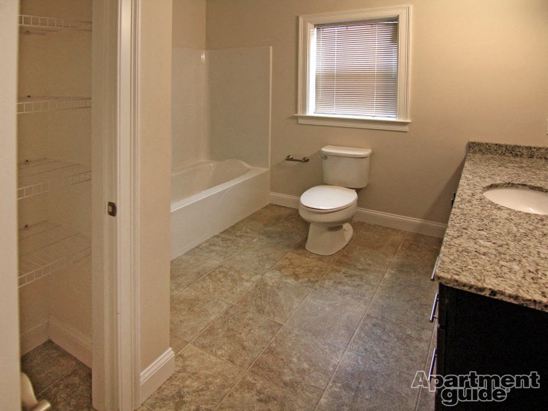 a bathroom with a toilet and a tub and a sink