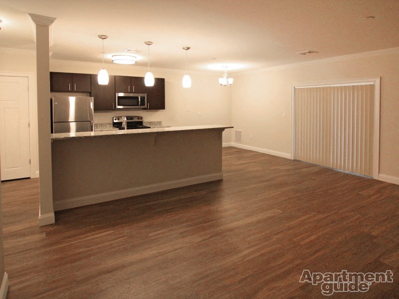 an empty living room with a kitchen and