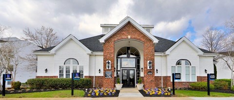 the front of a white house with a black door