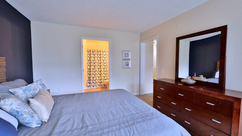 a bedroom with a large bed and a dresser