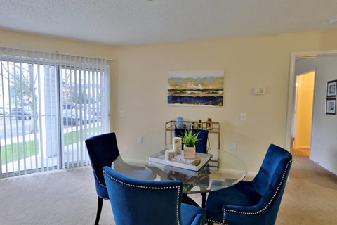 a dining room with a glass table and blue chairs