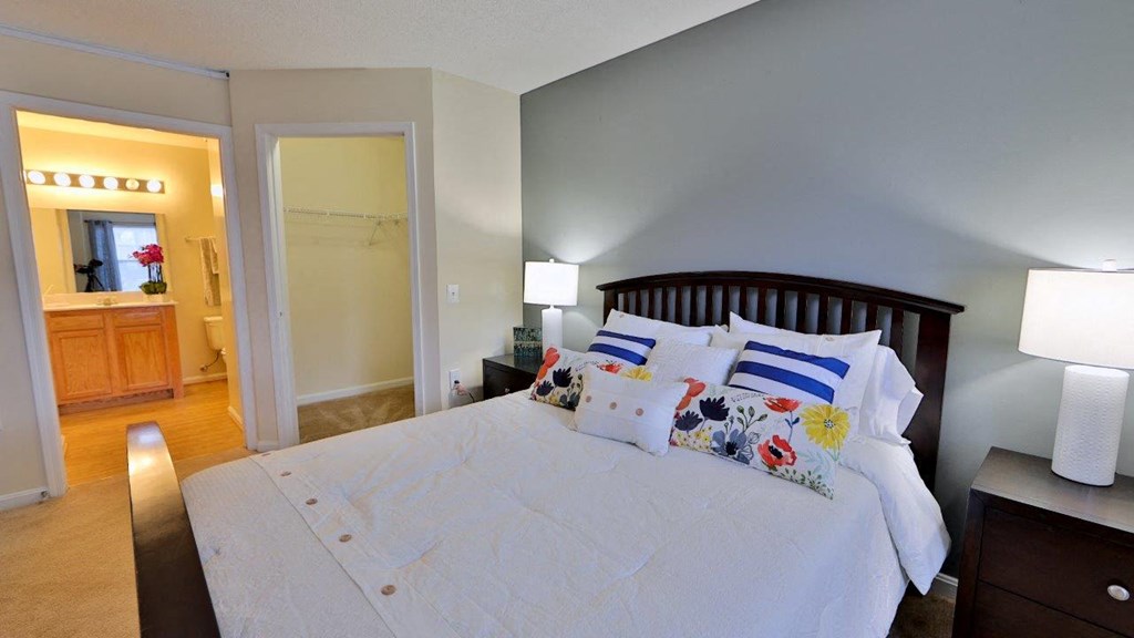 a bedroom with a large bed and a bathroom with a shower