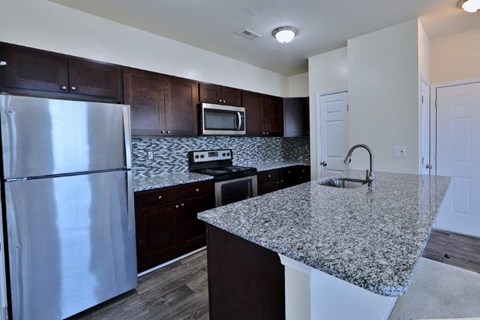 a kitchen with granite counter tops and stainless steel appliances