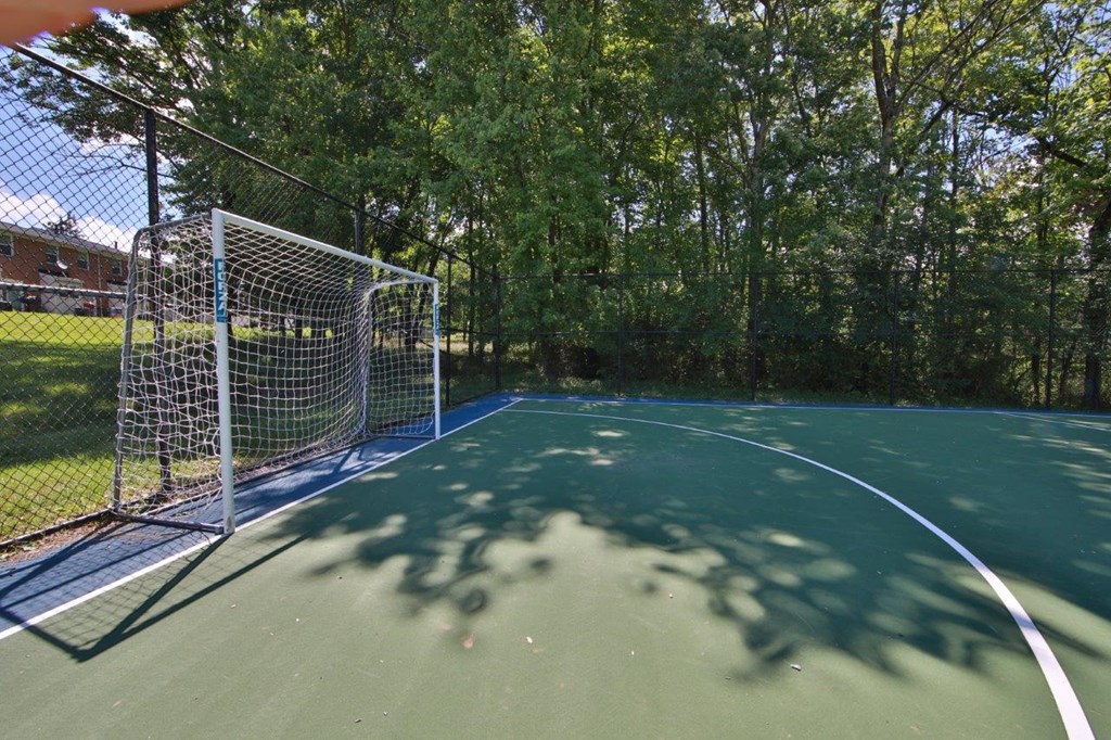 a fenced in tennis court with a net on it