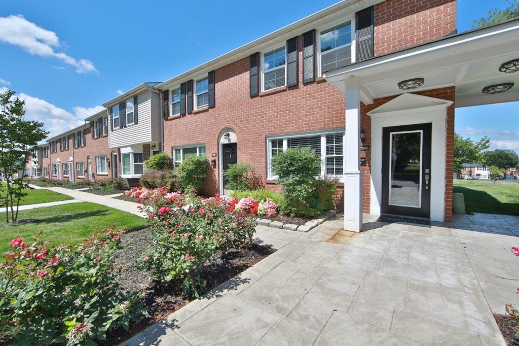 a sidewalk in front of a brick apartment building