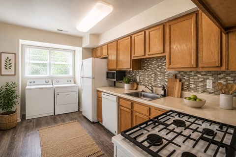 A kitchen with a black stove top oven and wooden cabinets.