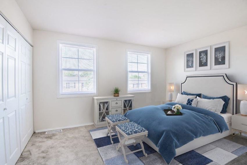 a bedroom with a bed and two windows