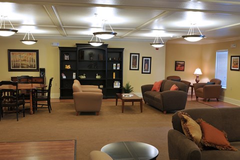 A living room with brown furniture and a fireplace.