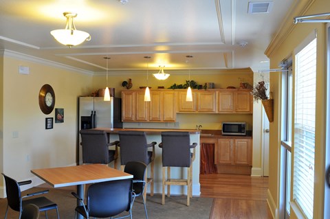 A kitchen with wooden cabinets and a table with chairs.