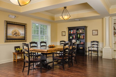 a dining room with a table and chairs and a bookshelf