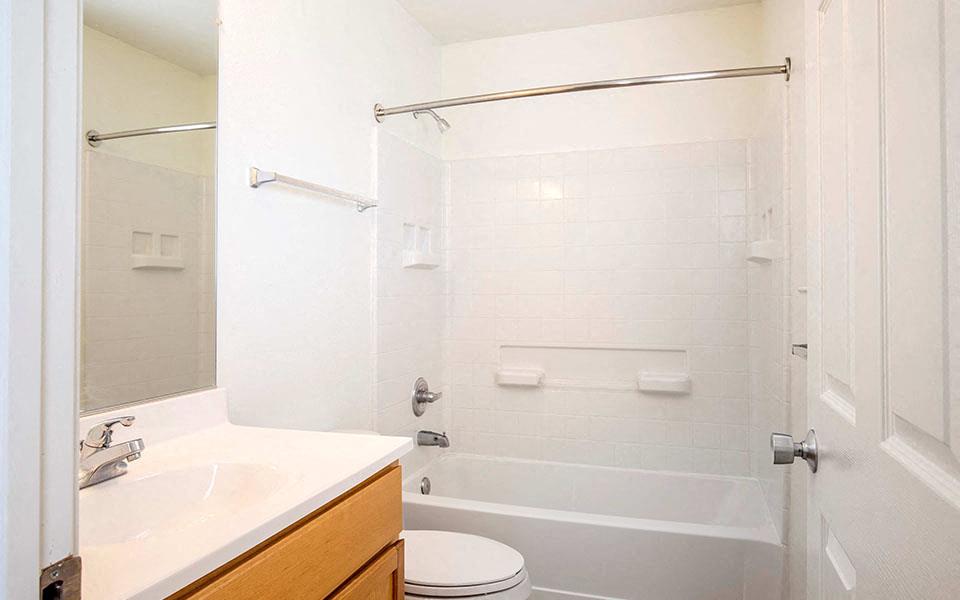 a white bathroom with a shower and a sink