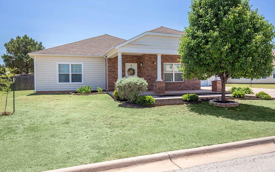a small white house with a tree in the front