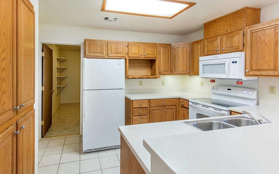 a kitchen with white appliances and wooden cabinets
