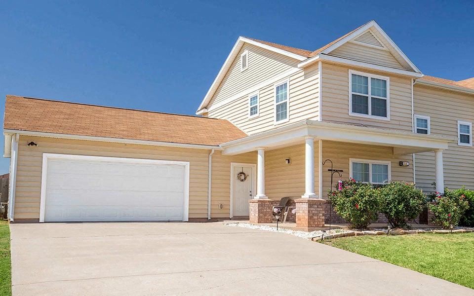 a yellow house with a white garage door