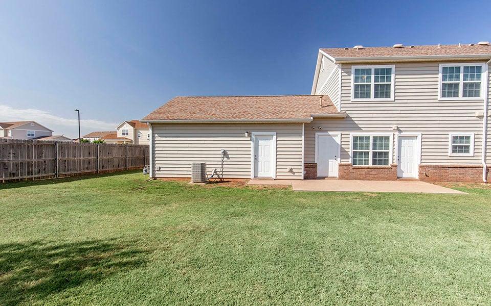 a white house with a yard and a wooden fence
