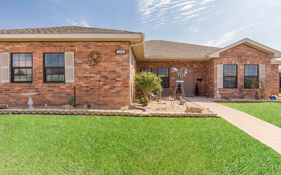 a brick house with a lawn in front of it