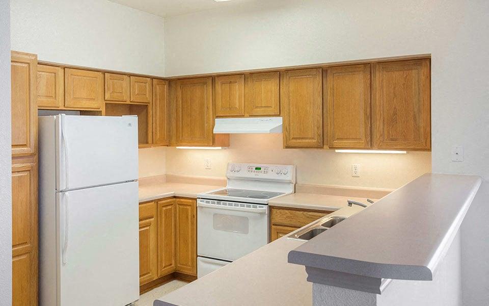 a kitchen with white appliances and wooden cabinets
