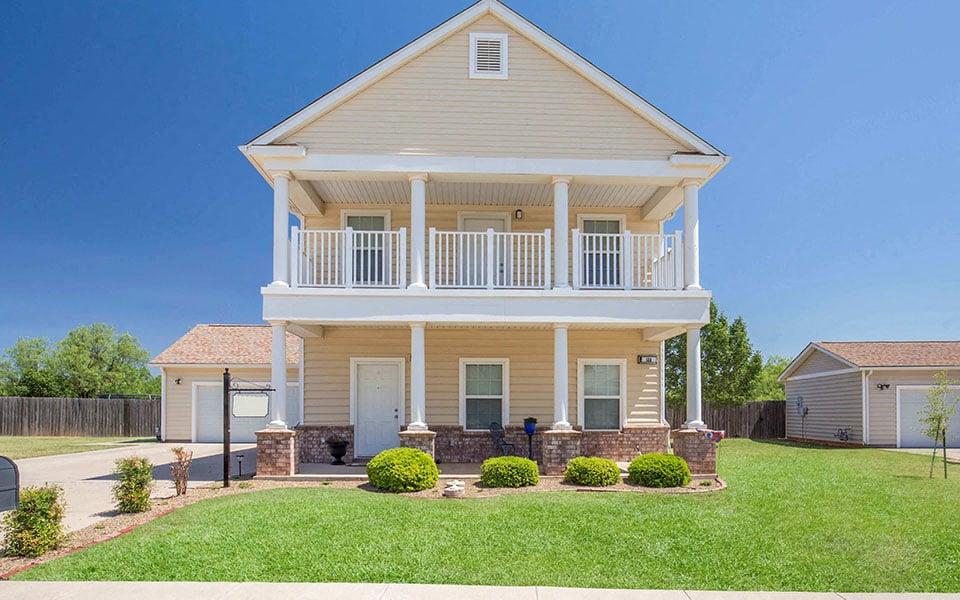 a white house with a porch and a lawn