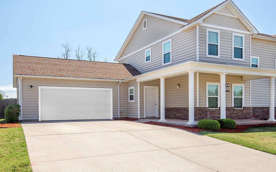a beige house with a white garage door