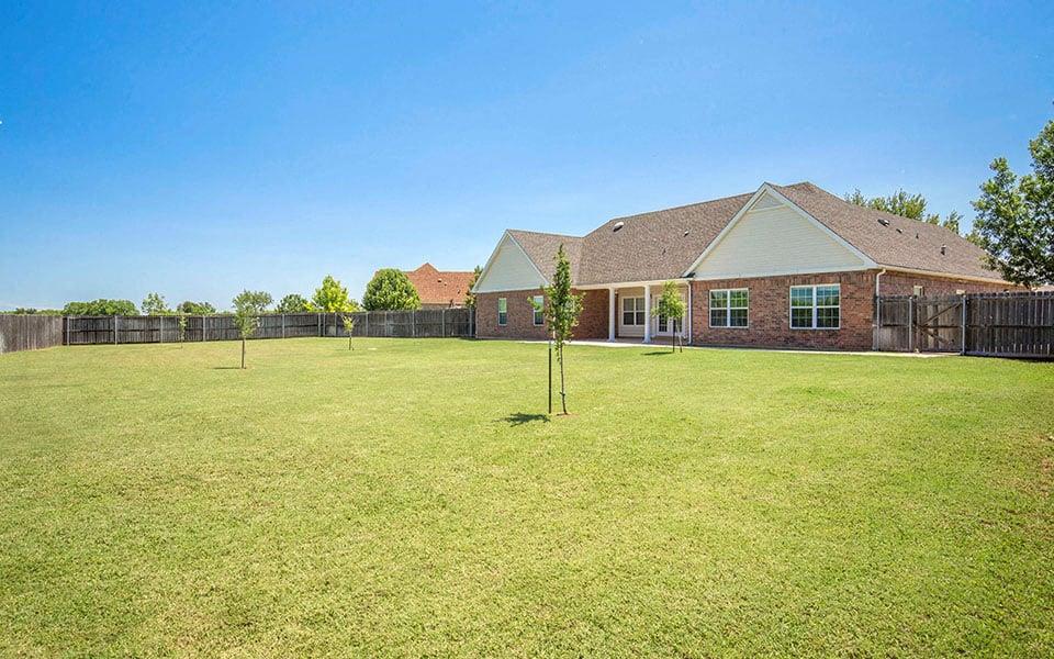 a large yard with a house in the background