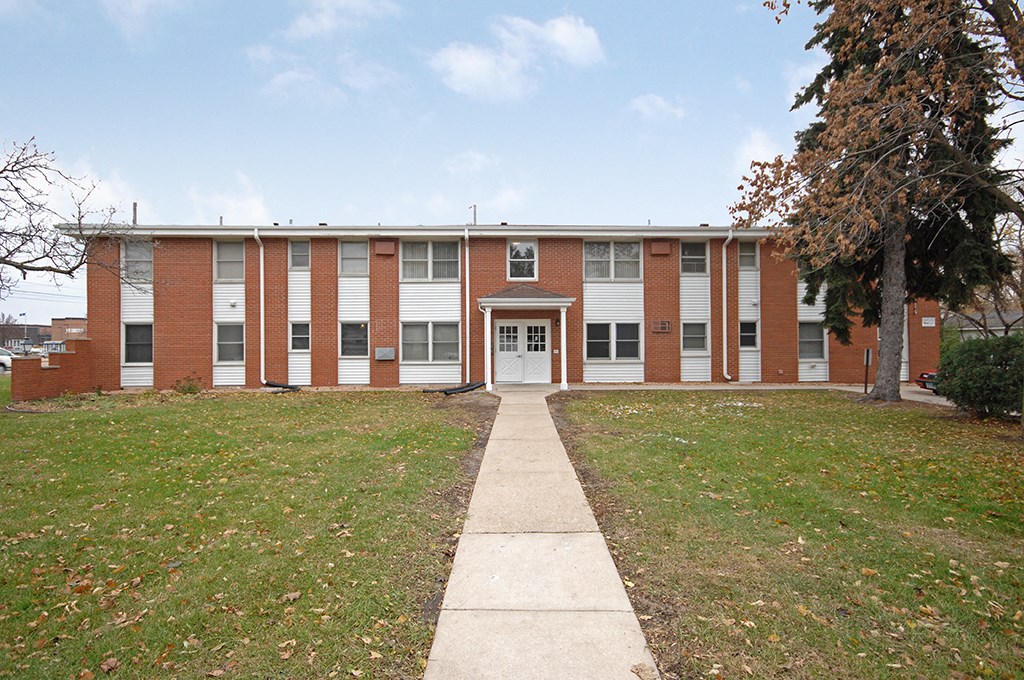 a large brick building with a sidewalk in front of it