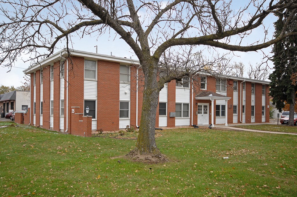 a large brick building with a tree in front of it