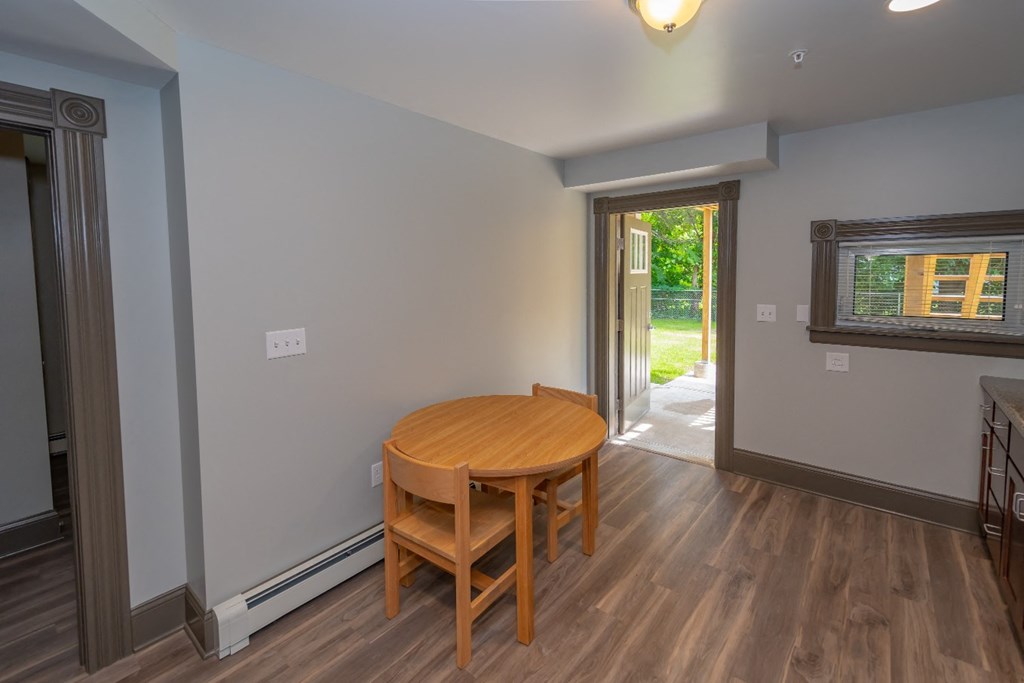 a dining room with a wooden table and chairs