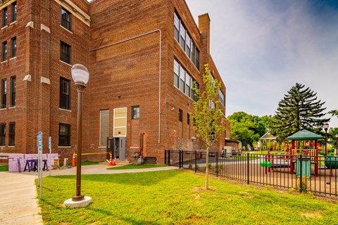 a large brick building with a playground in front of it