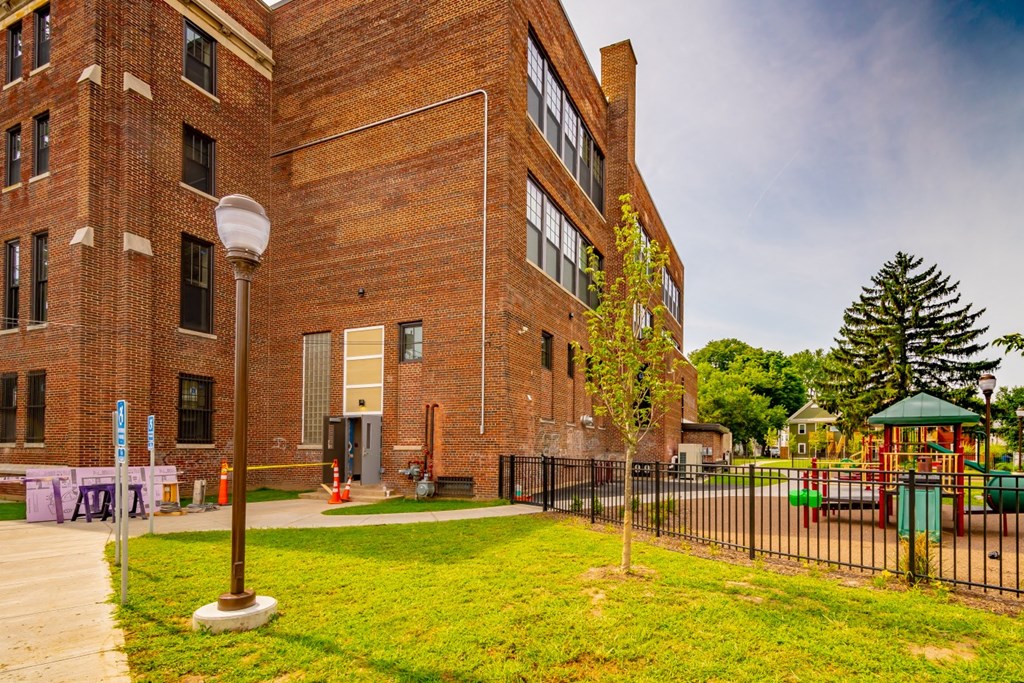 a large brick building with a playground in front of it