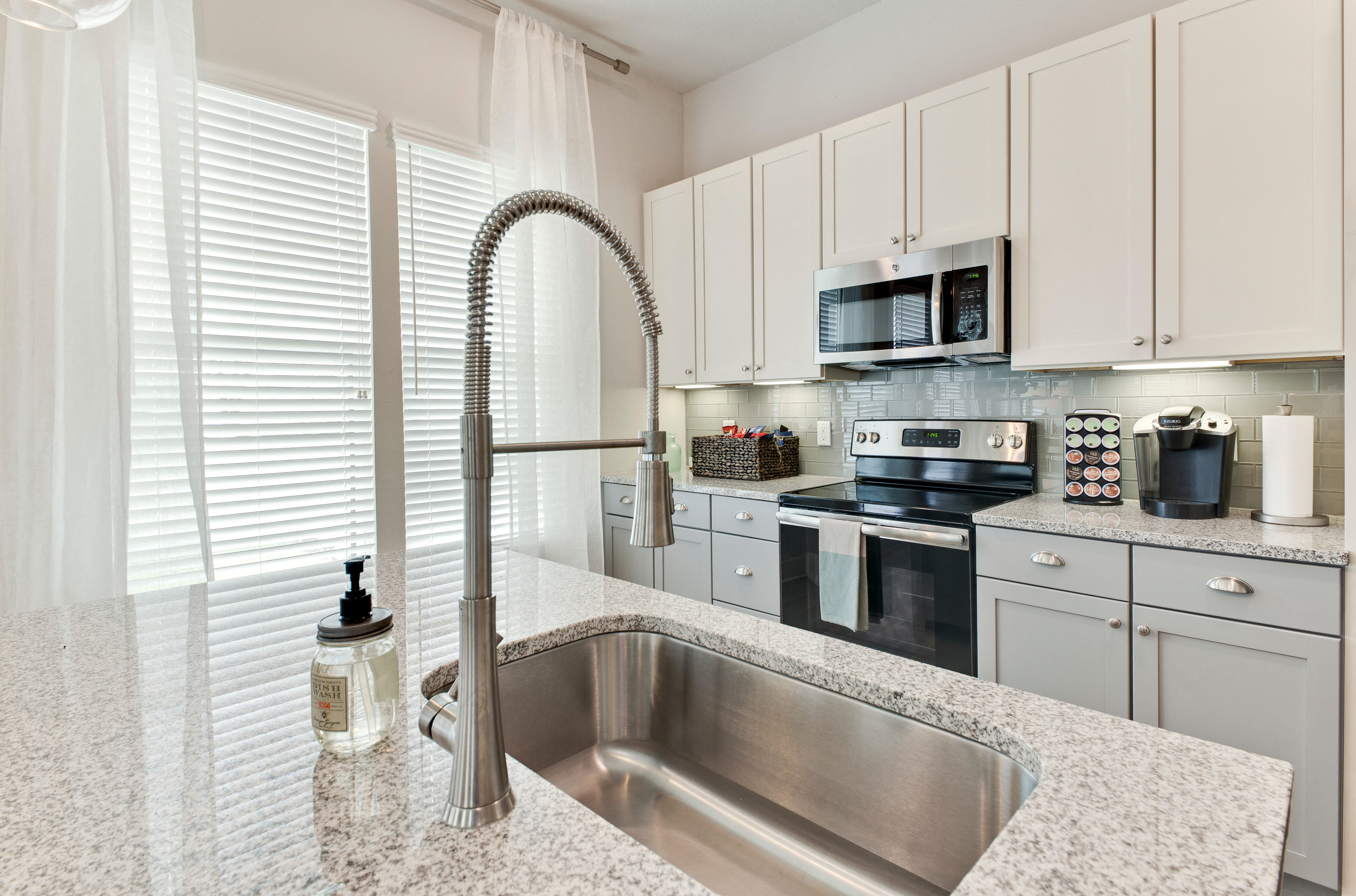 a kitchen with white cabinets and a sink