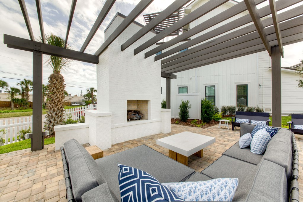 a patio with a couch and a coffee table and a fireplace