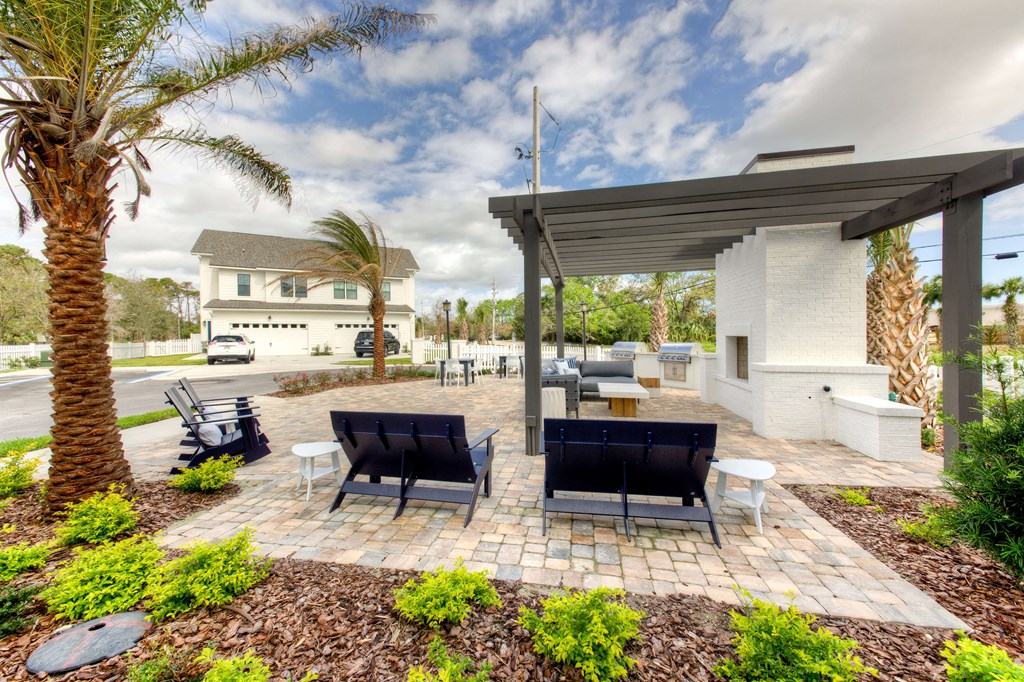 an outdoor patio with chairs and tables and a house