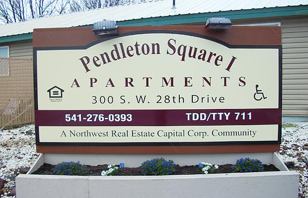 a sign for pendleton square apartments in front of a building
