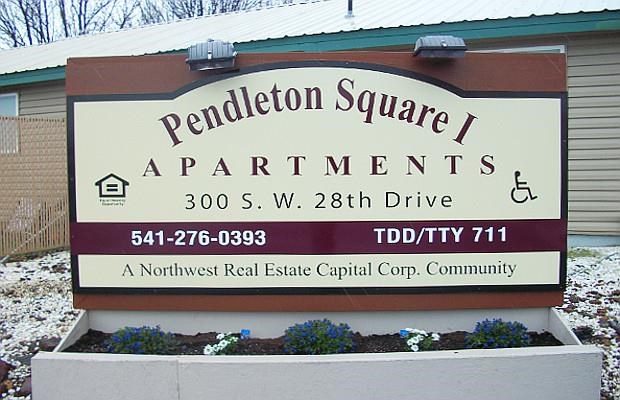 a sign for pendleton square apartments in front of a building
