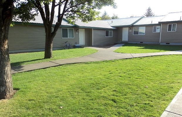 a row of houses with a sidewalk in the grass