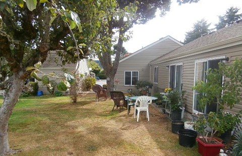 a backyard with a table and chairs and a house