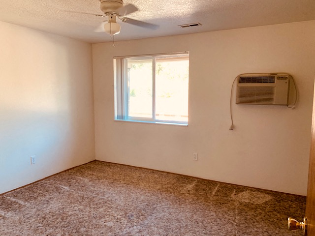 an empty room with a window and a air conditioner