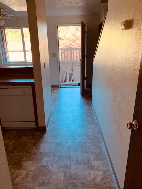 a hallway with a door to a kitchen and a balcony