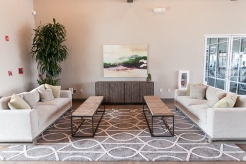 A living room with a large painting on the wall and a rug on the floor.