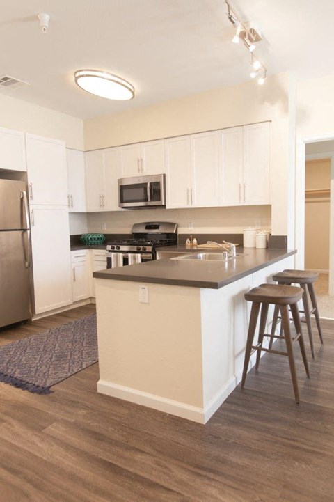 A kitchen with white cabinets and a black stove top.