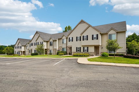 A large building with a parking lot in front.