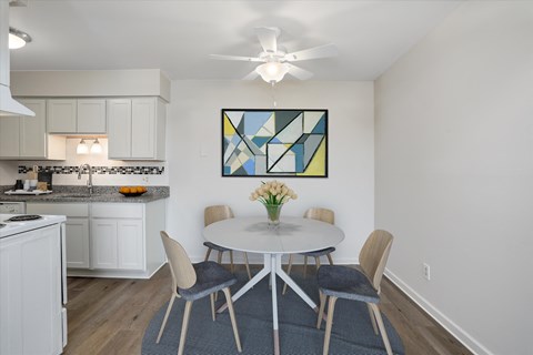 A kitchen with a dining table and chairs.