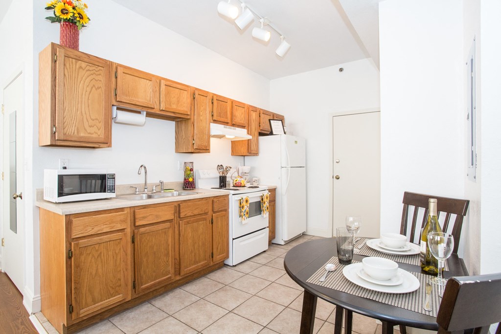 a kitchen with wooden cabinets and a dining table