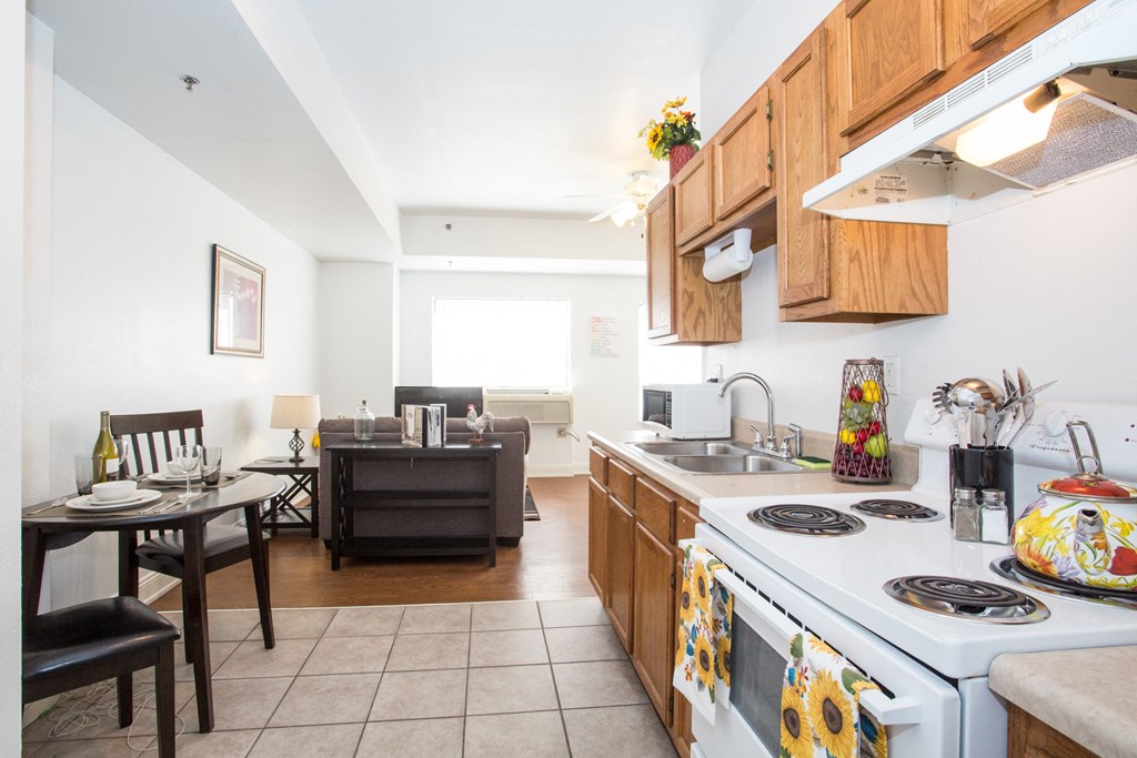 a kitchen with a stove and a sink and a dining room