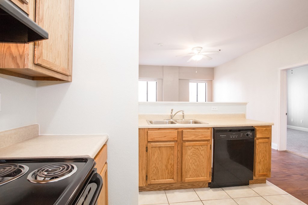 an empty kitchen with wooden cabinets and a stove and a sink